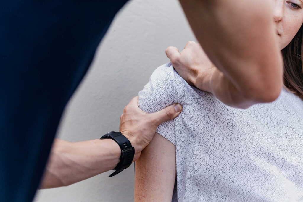 Physiotherapeut bei manueller Behandlung einer Patientin