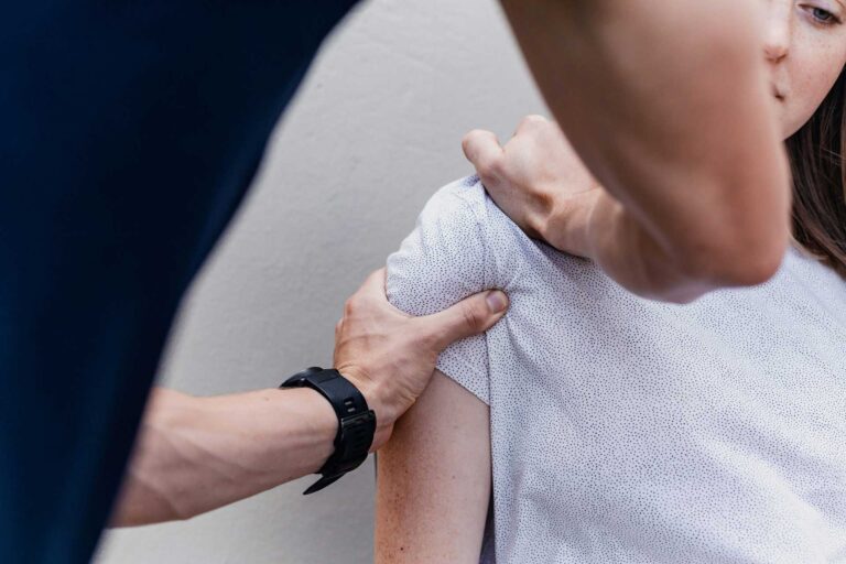 Physiotherapeut bei manueller Behandlung einer Patientin